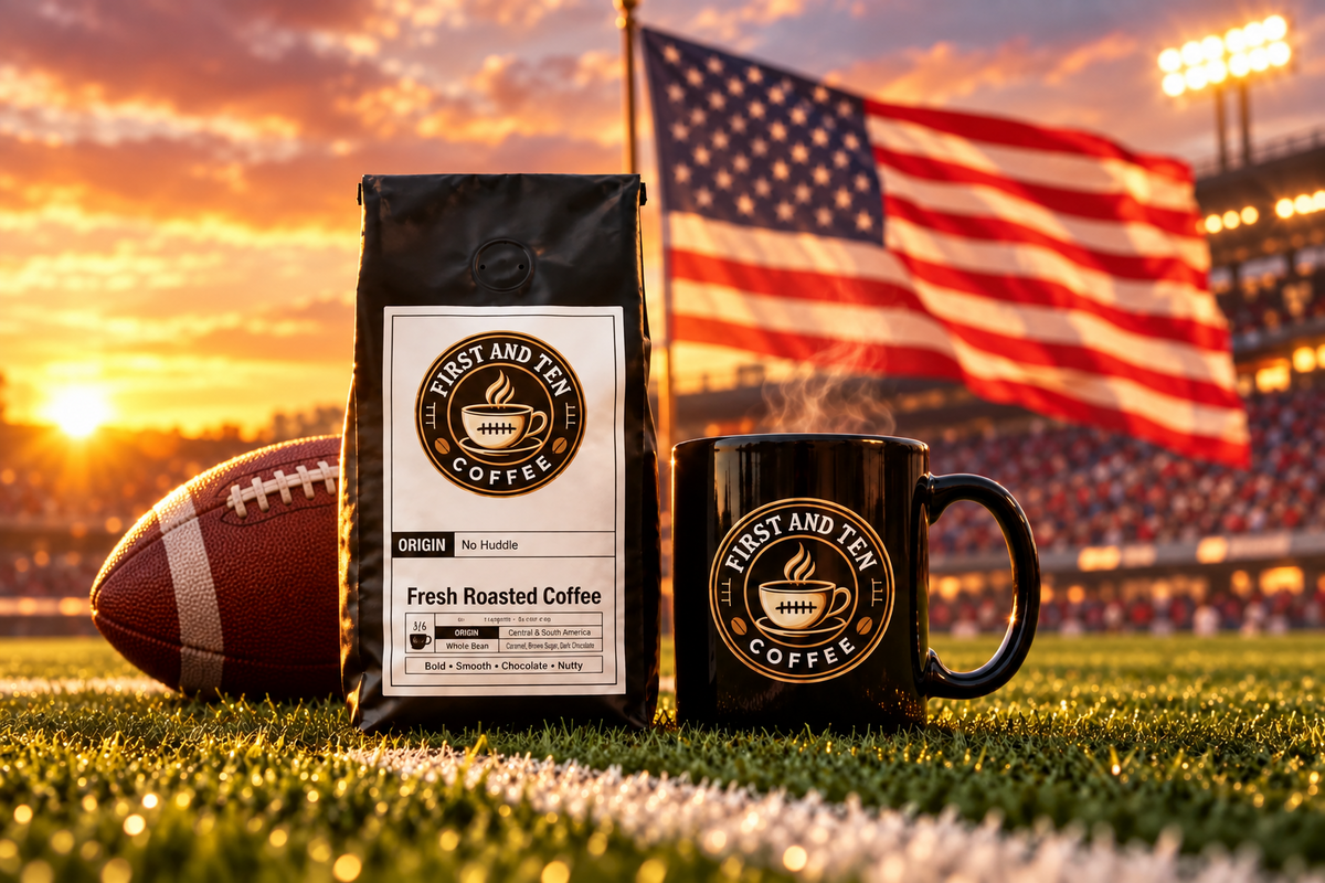 A bag of First and Ten Coffee and a matching black mug with the brand logo are placed on a football field at sunset, with a football and a large American flag in the background.